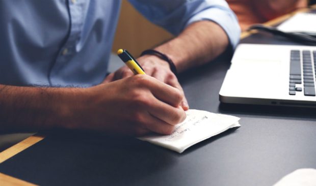 Image of male writing on paper