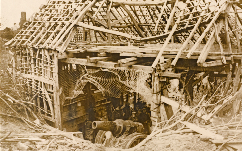 British soldiers inspect a German 8-inch gun in its emplacement in a ruined barn at Flesquieres, 24 November 1917