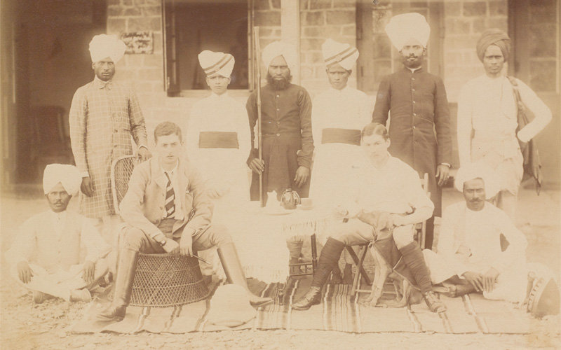 Charles Stooks (seated front left) with a colleague and their servants, Chakrata, 1898