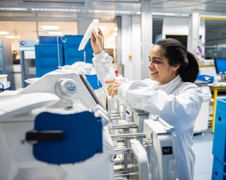 A member of staff in a manufacturing lab, using machinery