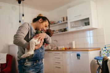 Woman holding baby in her kitchen