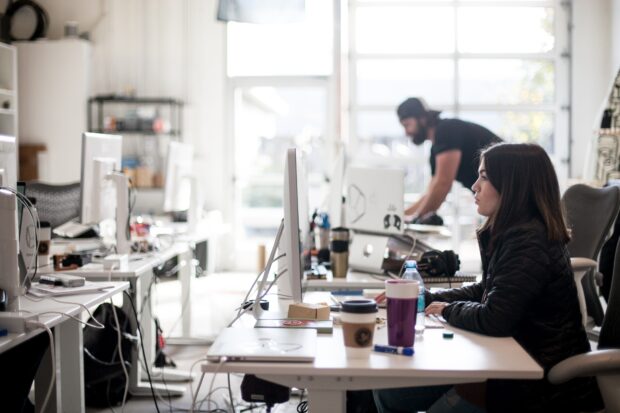 Woman sat at computer in a modern looking office.