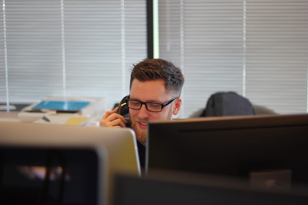 Male DfT Policy Professional answering his desk phone.