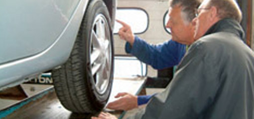 MOT testers looking at a wheel
