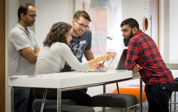 A group of 4 people at Hack the North 2.0 talk about ideas and solutions at the event