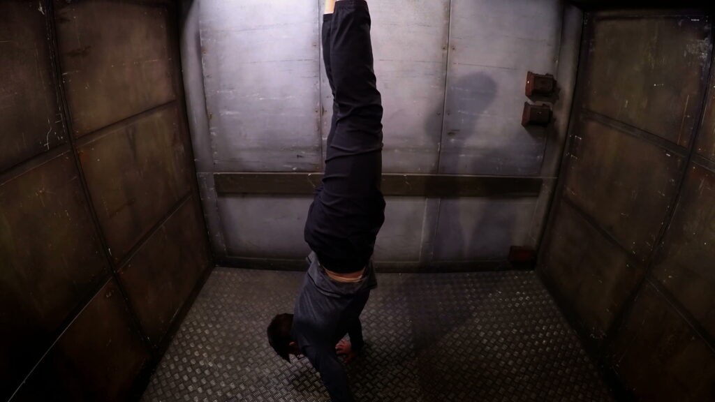 Louis doing a handstand in the lift.