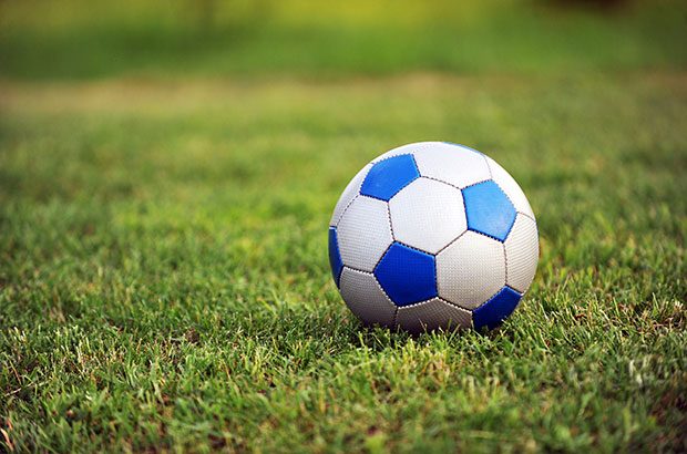 Blue and white football on a field.
