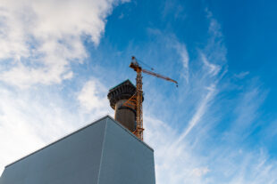 Colour image of the Windscale Chimney Pile 1 with a tower crane