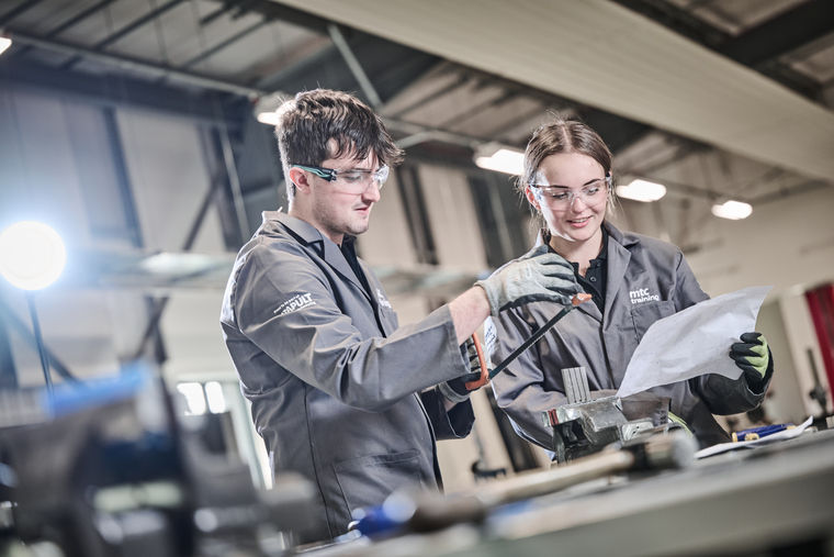 Apprentices learning skills in a workshop.