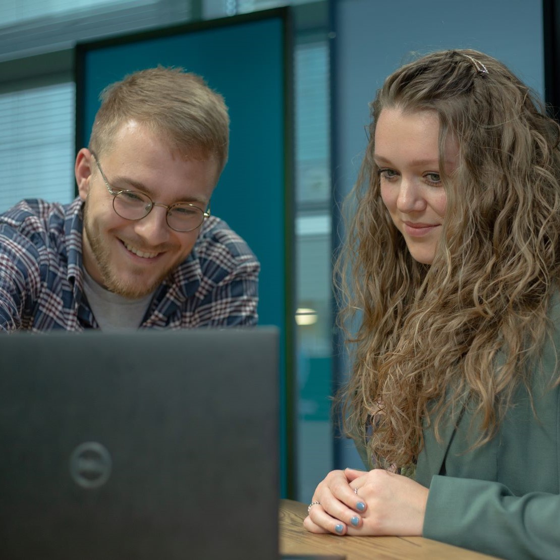 Two colleagues around a laptop - portrait.jpg