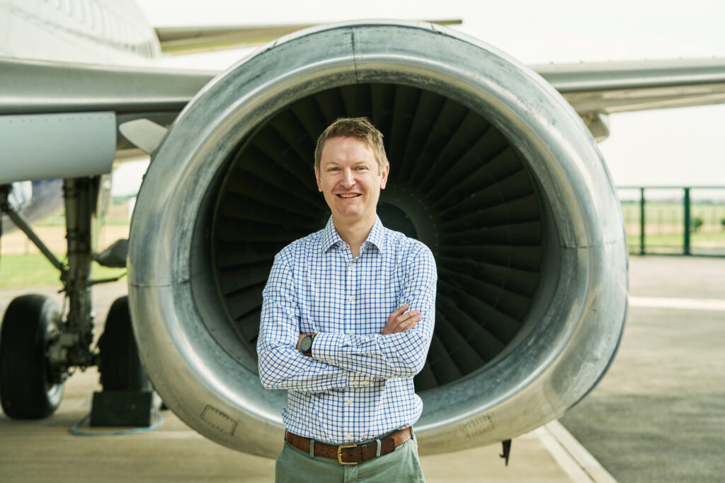 Male researcher standing infront of an aeroplane wing