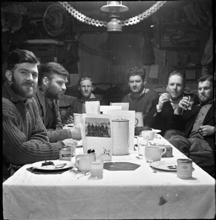 A black and white photo of a group of men sitting at a long table.