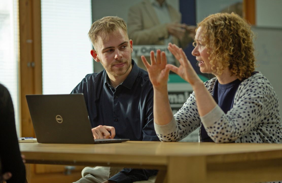 Two staff talking at a table.jpg