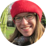A close up of a person wearing a hat and smiling at the camera