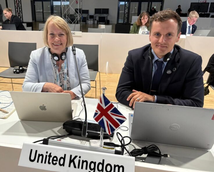 A group of people sitting at a desk with a laptop