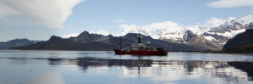 A large body of water with a mountain in the background
