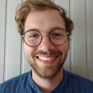 A man wearing glasses and smiling at the camera
