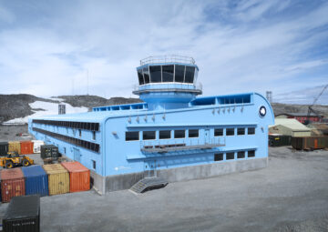a large blue building with a tower on the top of the roof