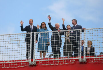 Prince William, Duke of Cambridge, David Attenborough et al. waving from bow of the research ship Sir David Attenborough.
