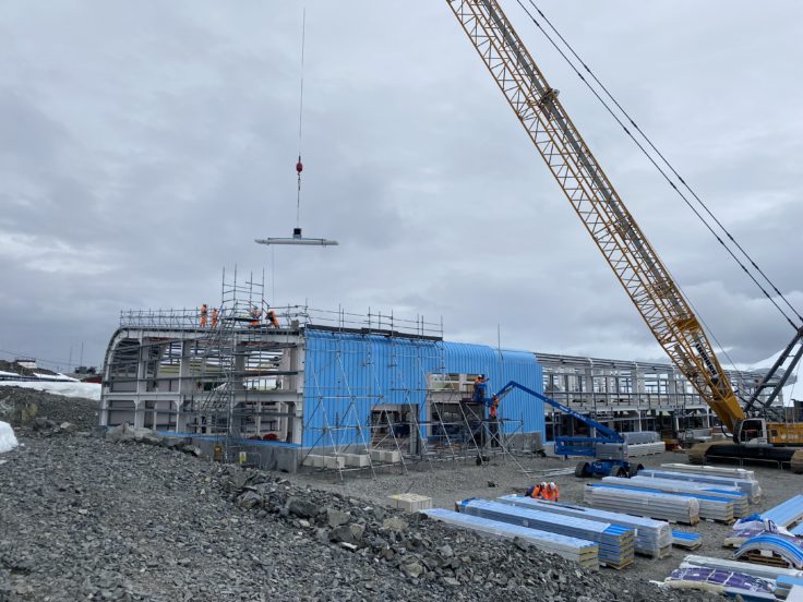 Crane lifting slabs into building being constructed