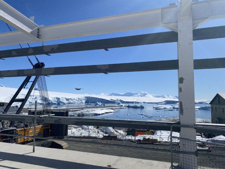 View of icy mountains through steel frame of building at Rothera in Antarctica