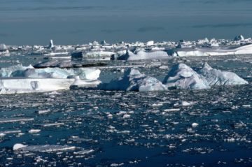 A large body of water with a reseach station in the background.