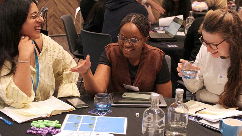 Three early career researchers talking at a table