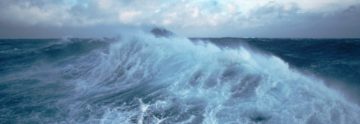A man riding a wave on top of a body of water.