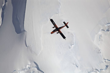 A person flying through the air on a snow covered slope.