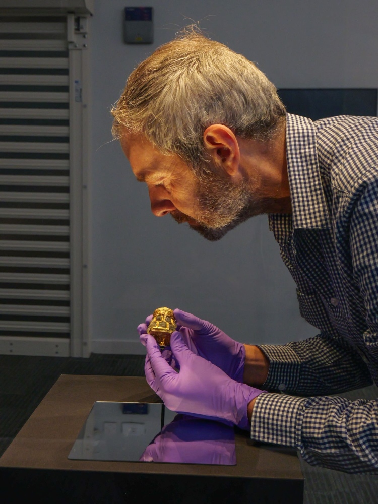 Curator Craig Angus puts the finishing touches to the installation of the Rock Crystal Jar.