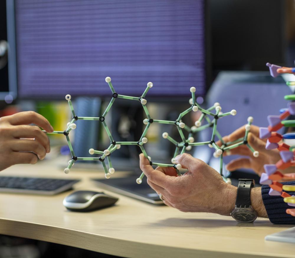Drug discovery consultancy - A model of a molecule being held on a desk.