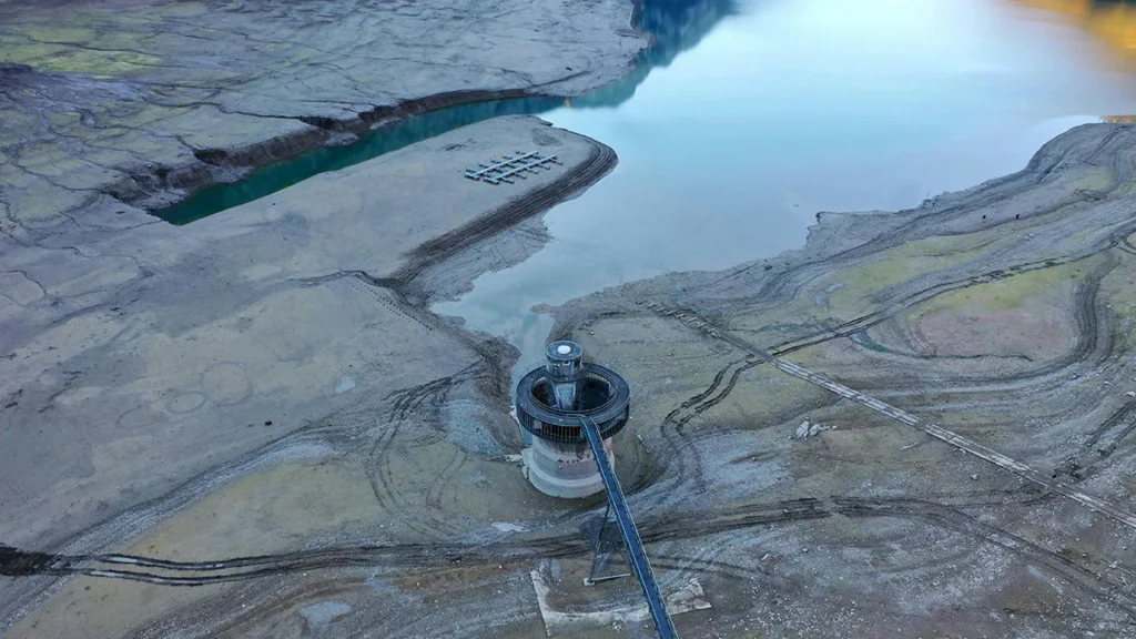 Dry reservoir, with exposed soil and reservoir building