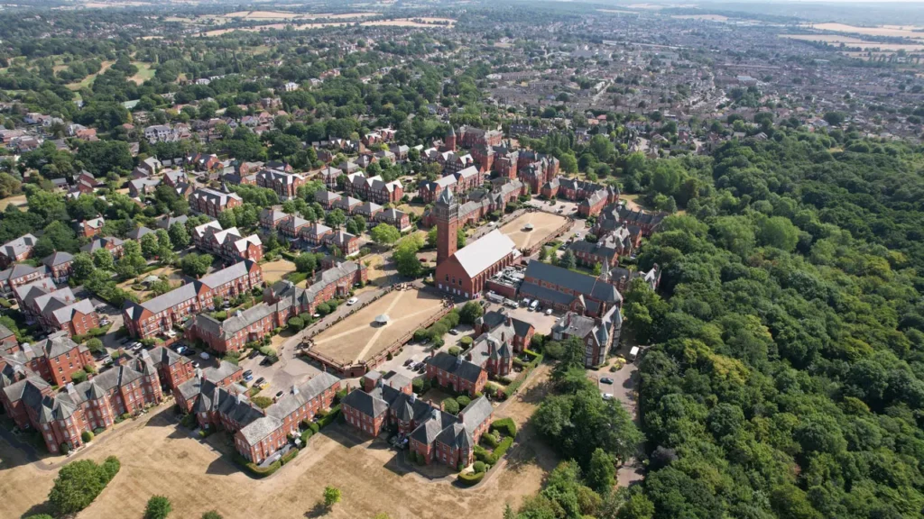 London city from above. Houses, yellow grass and green trees.