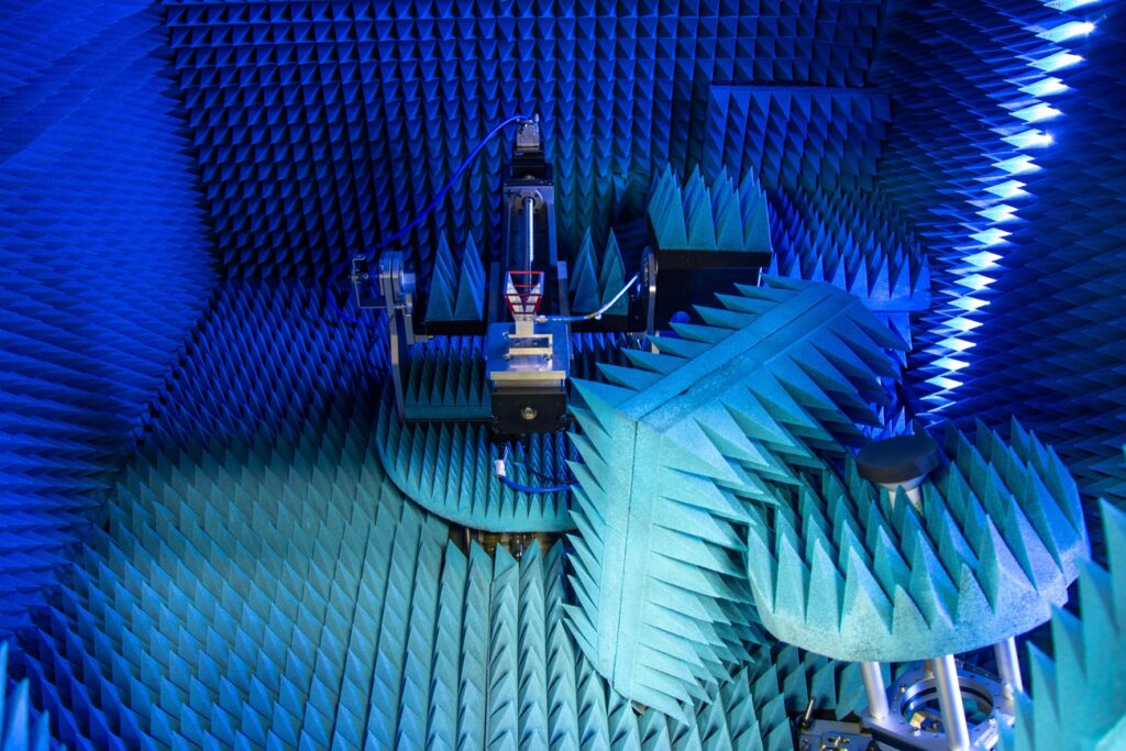 Room with blue anechoic foam panels and equipment for testing electromagnetic waves.