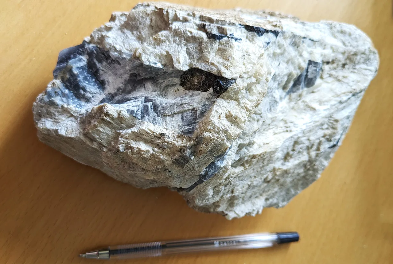 Skarn rock with calcite veins in the centre and aragonite ooids on the right. BGS © UKRI.