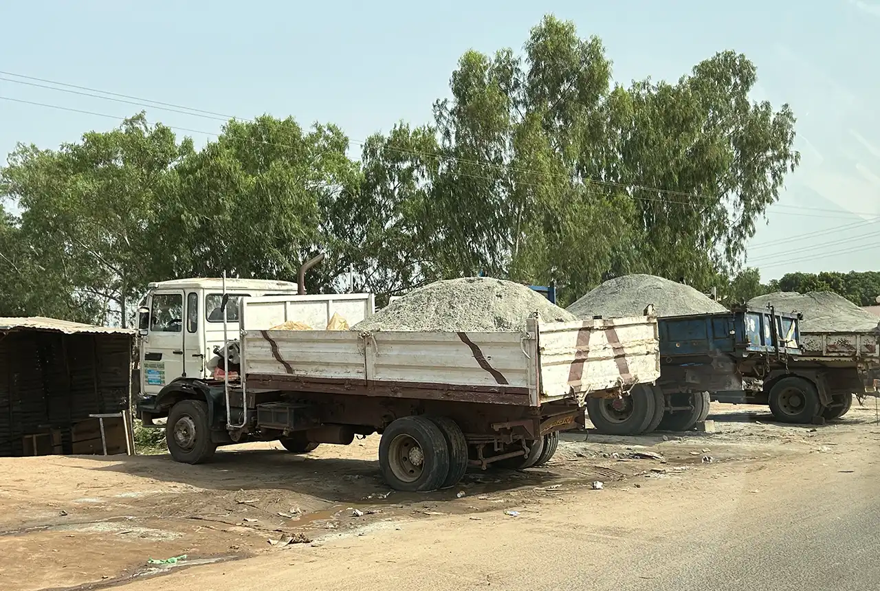 Sand trucks waiting for customers in The Gambia. BGS © UKRI.