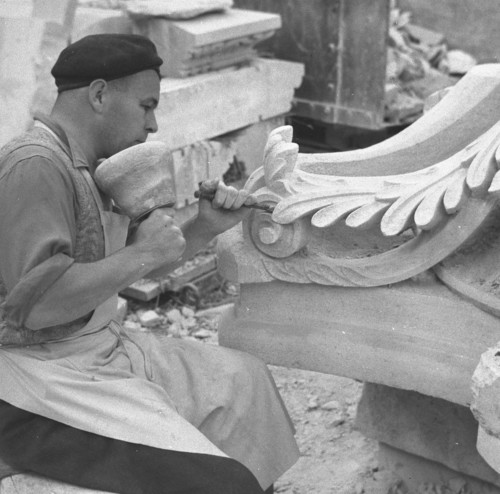 A stone mason carving a block of stone