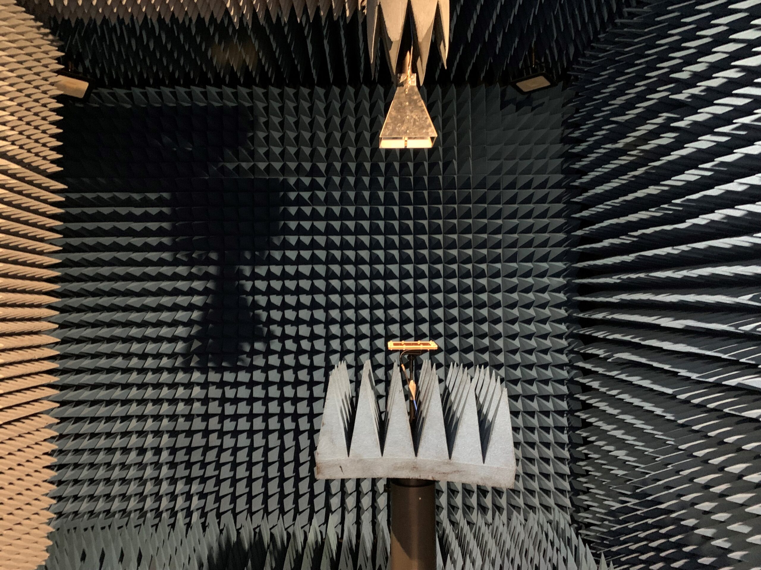 Room with spiked foam walls, a small platform, and mounted equipment in the center.
