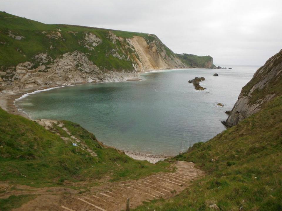 Man o' War Cove and St Oswald's Bay, west of Lulworth, Dorset: a wide, crescent-shaped bay with white cliffs