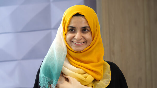 Woman in an office setting smiling at camera.