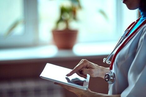 Clinician using an electronic device (a tablet)