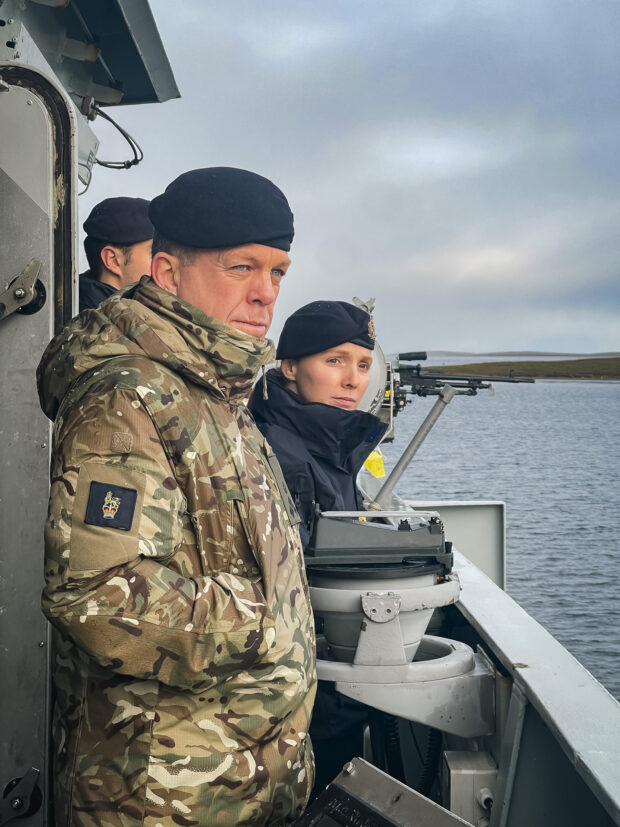 Naval personnel looking out to sea from HMS Forth