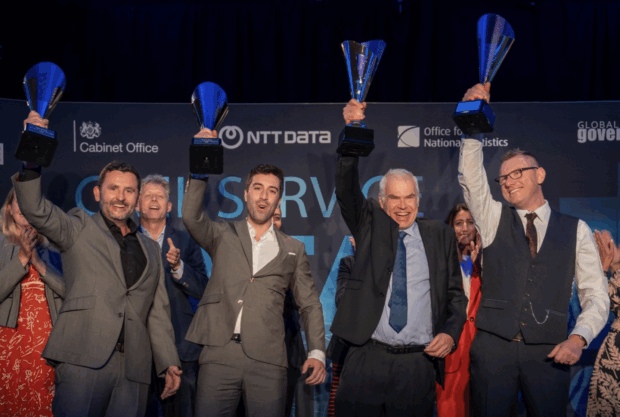 A group of people celebrating and hold a trophy from the Civil Service Data Challenge 2024. Projection Constellation celebrate winning Civil Service AI & Data Challenge 2024.