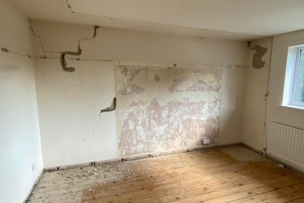 Interior house wall with cracked and damaged plaster board.