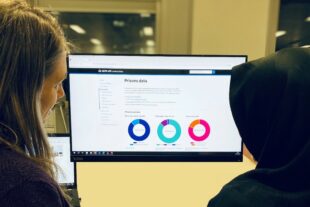 Two people looking at justice data on a computer screen.