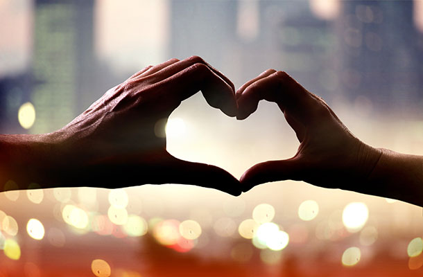 Image of hands creating a heart shape in the air.