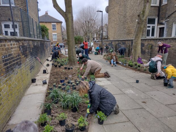 Members of a community work on a project to increase biodiversity on a London thoroughfare