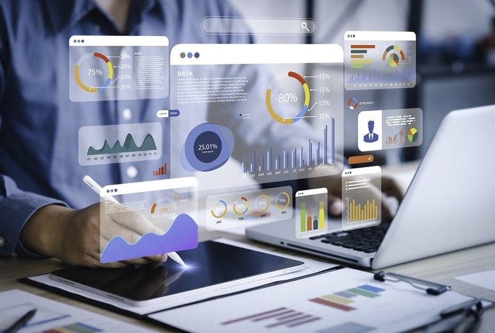 People typing at laptops with data images floating above. Credit: iStock Photo