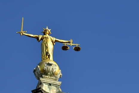 The Scales of justice statue on top of the old bailey couthouse in Southwark inner London UK. Taken on a clear spring day under a deep blue sky with lots of copy space. No filters were used on this file.