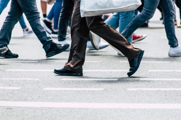 Current image: Photo of people's legs, walking along a high street with shopping bags.